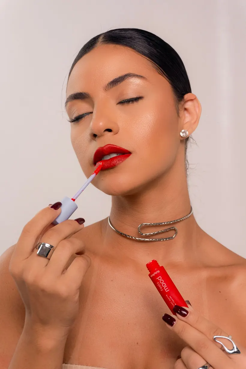 Aplicación de labial rojo en un maquillaje editorial