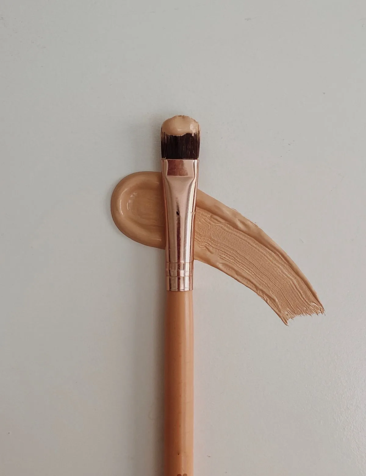 Brocha de maquillaje sobre base beige para calcular materiales de un curso online