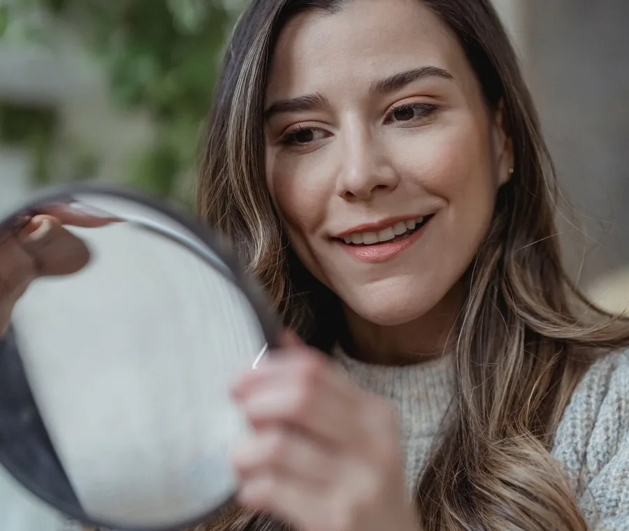 Mujer sonriendo con luz natural después de decidir con calma sobre un curso de belleza online